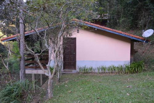 a small white building with a brown door at Pousada Moinho Azul in Teresópolis