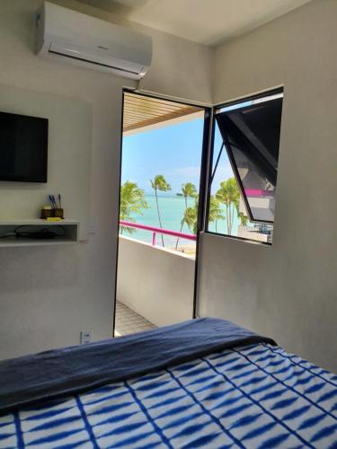 a bedroom with a bed and a view of the beach at Vista pro mar in Maceió