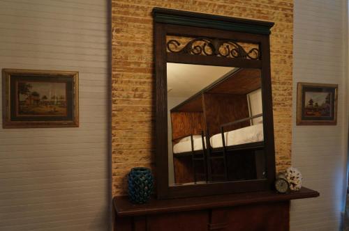 a mirror sitting on a wooden dresser in a room at HOSTEL Auberge Clarksdale in Clarksdale