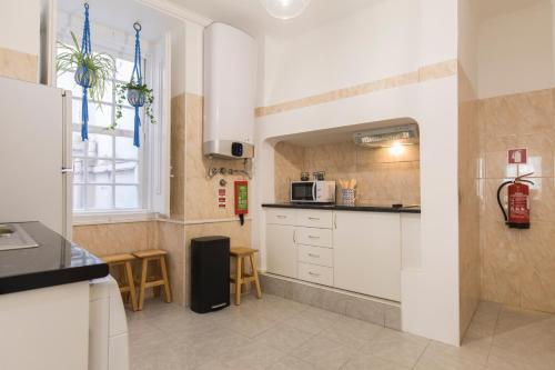 a kitchen with white cabinets and a window at Blue Tiles in City Center in Lisbon