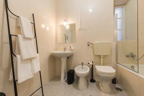 a white bathroom with a toilet and a sink at Blue Tiles in City Center in Lisbon