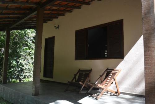 two chairs sitting on the porch of a house at Pousada Moinho Azul in Teresópolis