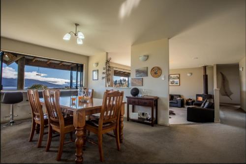 a dining room and living room with a table and chairs at Loch Vista Bed & Breakfast in Te Anau
