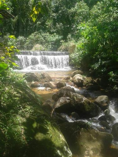 a waterfall in the middle of a river with rocks at Pousada Moinho Azul in Teresópolis