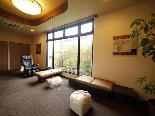 a living room with a large window and a couch at Hotel Route-Inn Dai-ni Kameyama Inter in Kameyama