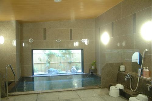 a large swimming pool in a bathroom with a large aquarium at Hotel Route-Inn Dai-ni Kameyama Inter in Kameyama