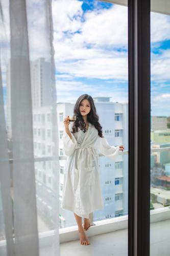 a woman in a white dress standing on a window at Luu Ngai Condotel Quy Nhon in Quy Nhon