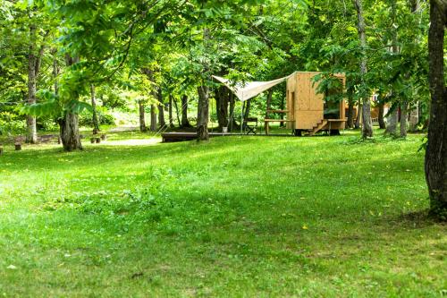 a tent in the middle of a park with trees at Snow Peak Jyubako（AKAIGAWA TOMO PLAYPARK） in Akaigawa