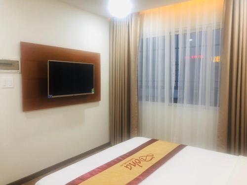 a bedroom with a bed with a tv on the wall at Doha 2 Hotel Saigon Airport in Ho Chi Minh City