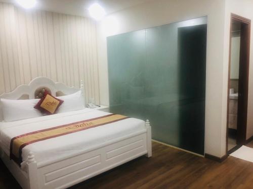 a bedroom with a white bed with a green wall at Doha 2 Hotel Saigon Airport in Ho Chi Minh City