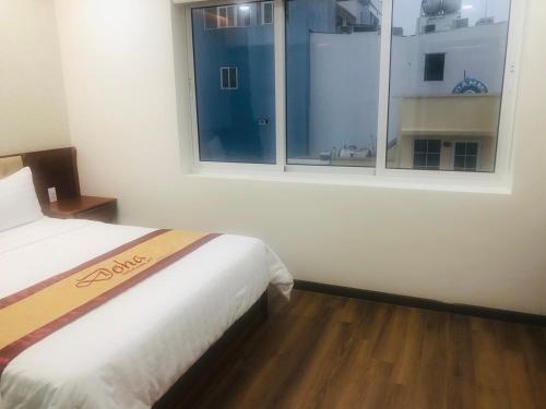 a bedroom with a bed and a large window at Doha 2 Hotel Saigon Airport in Ho Chi Minh City