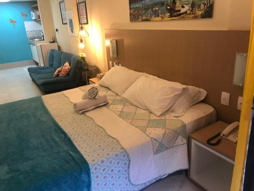 a small bedroom with a bed and a couch at Pipa Flat Top Ocean Residence in Pipa