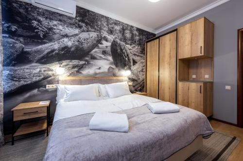 sypialnia z dużym łóżkiem z obrazem na ścianie w obiekcie Hotel "Na Kamushkah" w mieście Biełokuricha