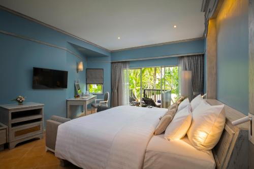 a bedroom with a large white bed and a window at Aonang Villa Resort - SHA Extra Plus in Ao Nang Beach