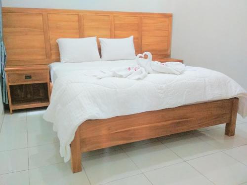 two swans sitting on top of a bed at Wisma Andany in Jepara