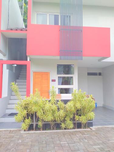 a building with an orange door and some plants at Wisma Andany in Jepara