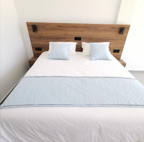 un grande letto con lenzuola e cuscini bianchi di Shalos Studios a Ayia Napa