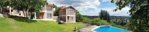a house with a swimming pool in the yard at C&W Vacaciones Diferentes in Villa Carlos Paz