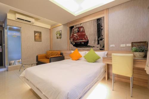 a bedroom with a large bed with orange and green pillows at LJ Hotel in Kaohsiung