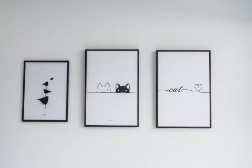 three frames with cats and birds on a wall at Boléro Homestay I 鄰近花園夜市 in Tainan
