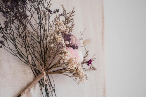 a vase filled with dried flowers on a wall at Boléro Homestay I 鄰近花園夜市 in Tainan