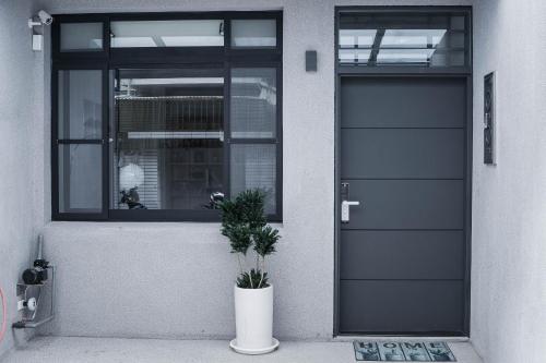 a front door of a house with a potted plant at Boléro Homestay I 鄰近花園夜市 in Tainan