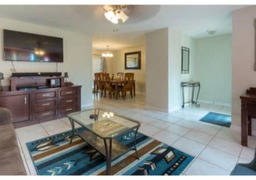 a living room with a table and a dining room at Home away from Home! in Deltona