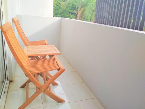 two wooden chairs sitting on top of a balcony at Wisma Andany in Jepara