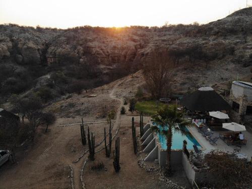a view of a resort with a swimming pool and a mountain at Sasa Safari Camp & Tours in Outjo