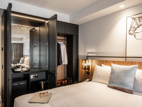 a bedroom with a bed with a mirror and a sink at Mercure Sydney Rouse Hill in Kellyville