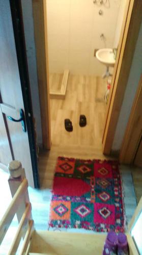 a bathroom with a rug on the floor next to a sink at Prenociste B&M - Lukomir in Lukomir