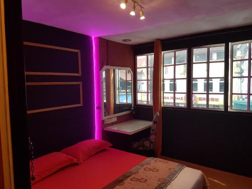 Dormitorio con cama con iluminación púrpura en City Inn Hotel en Kuala Lumpur