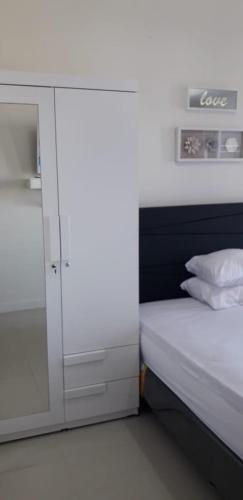 a small bedroom with a bed and a cabinet at Vida View Apartement, Tower Asthon Unit 20 P in Makassar