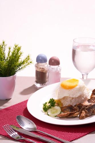 a plate of food with an egg and broccoli on a table at Griffin Hotel and Suites in Cebu City