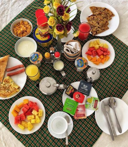 a table topped with plates of food and fruit at Mbeya Hotel in Mbeya
