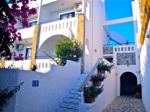 a stairway leading up to a building with potted plants at Ekaterini Hotel in Kiotari
