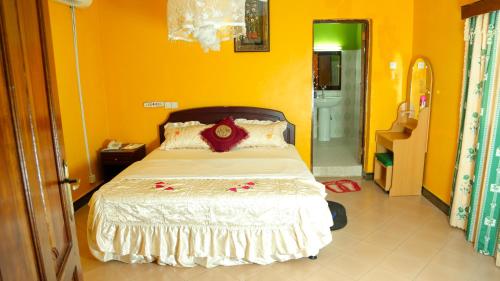 a bedroom with a bed in a yellow room at Mbeya Hotel in Mbeya