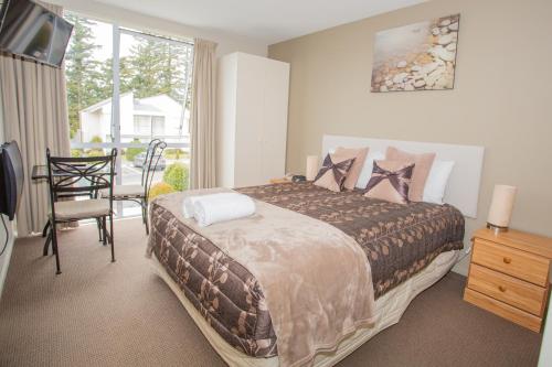 a bedroom with a bed and a table and a window at Brinkley Resort in Methven