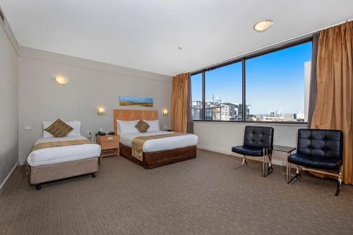 Quality Hotel Ambassador Perth في بيرث: غرفة فندقية بسريرين ونافذة كبيرة