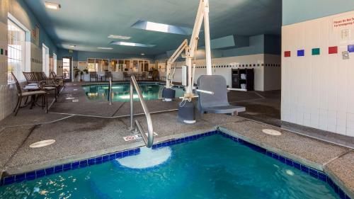 a swimming pool in a building with chairs and tables at Best Western Plus Liberty Lake Inn in Spokane Valley
