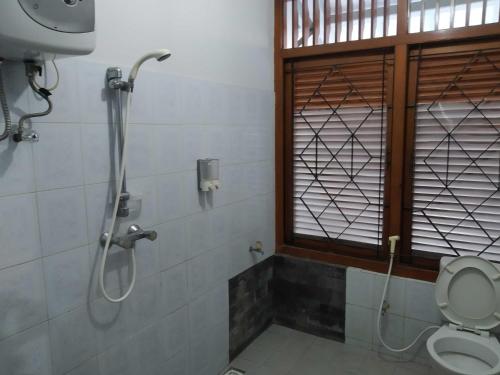 a bathroom with a shower and a toilet at Embe Enem Homestay in Yogyakarta