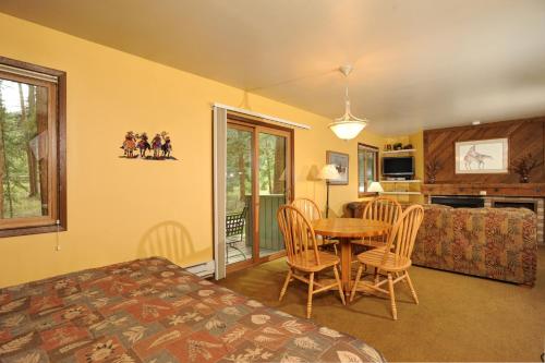 a bedroom with a bed and a table and chairs at The Forest Neighborhood by Keystone Resort in Keystone