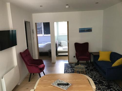 a living room with a couch and two chairs and a table at Entre mer et commerces in Wimereux