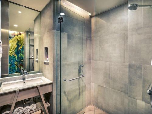 a bathroom with a shower and a sink at Mercure Kuta Bali in Kuta