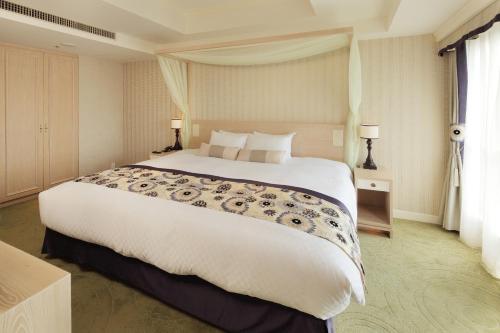 a bedroom with a large white bed in a room at Kumamoto Hotel Castle in Kumamoto