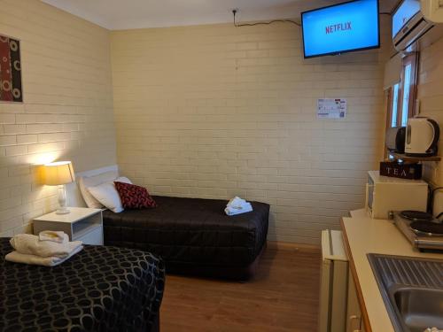 sala de estar con sofá y TV en Bondi Motel, en Moree