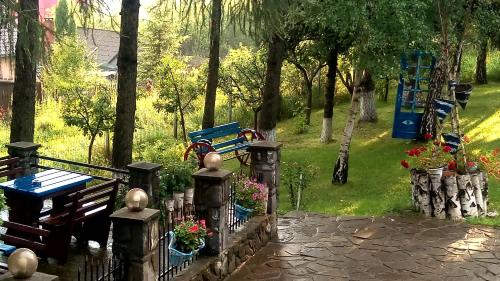 a park with a bench and a fence with flowers at pensiunea Gabriela in Durau