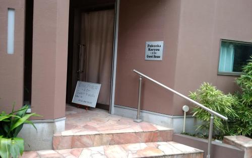 a building with a sign on the side of it at FukuokaKoryou GuestHouse in Fukuoka