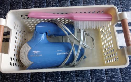 a plastic container with a hair dryer and a brush at FukuokaKoryou GuestHouse in Fukuoka
