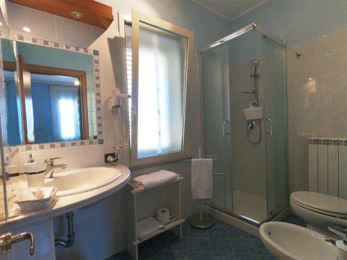 a bathroom with a sink and a shower and a toilet at Sweet Home B&B in San Ferdinando